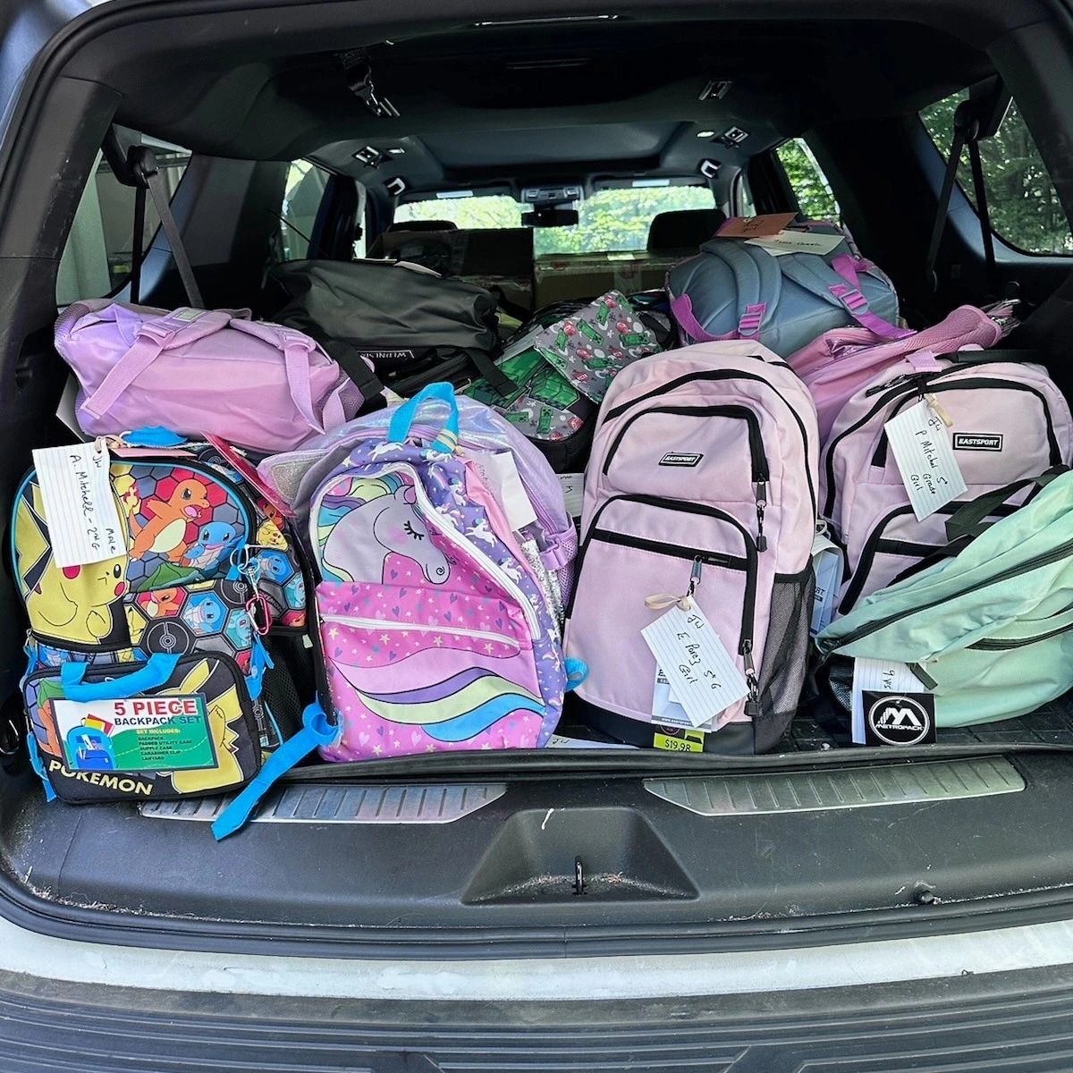 A car trunk filled with donated backpacks